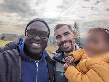 Frederic smiles for a selfie his husband and child